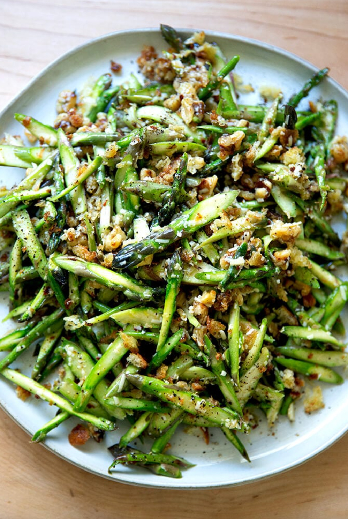 plate of raw asparagus salad with walnuts and parmesan