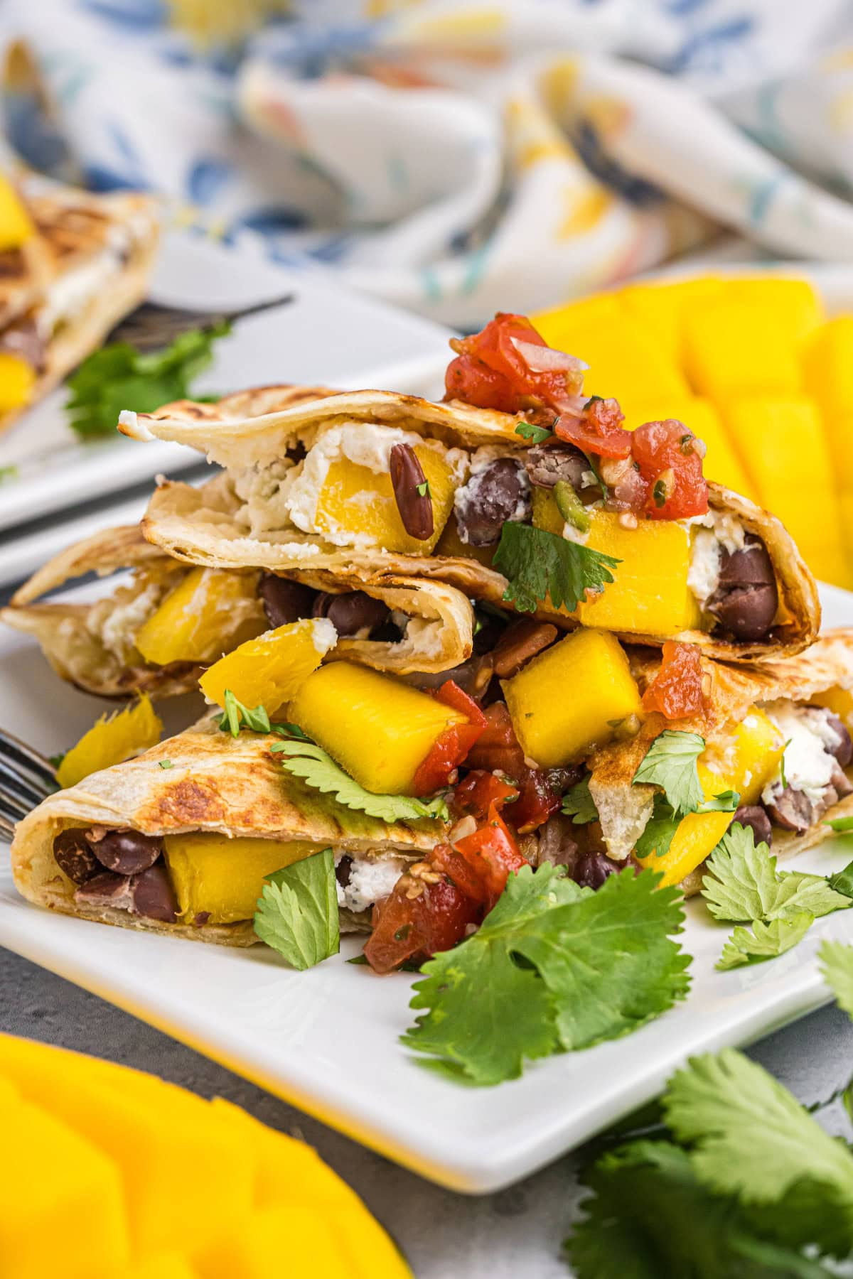 slices of mango black bean and goat cheese quesadilla stacked on plate