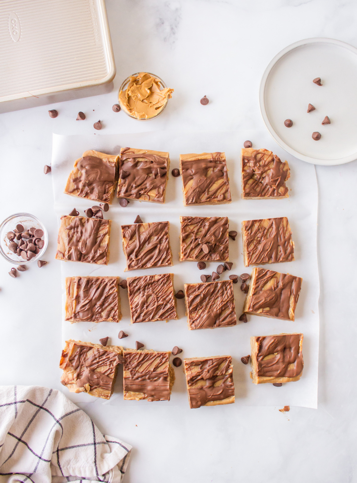 creamy peanut butter fudge with chocolate swirl cut into pieces on cutting board