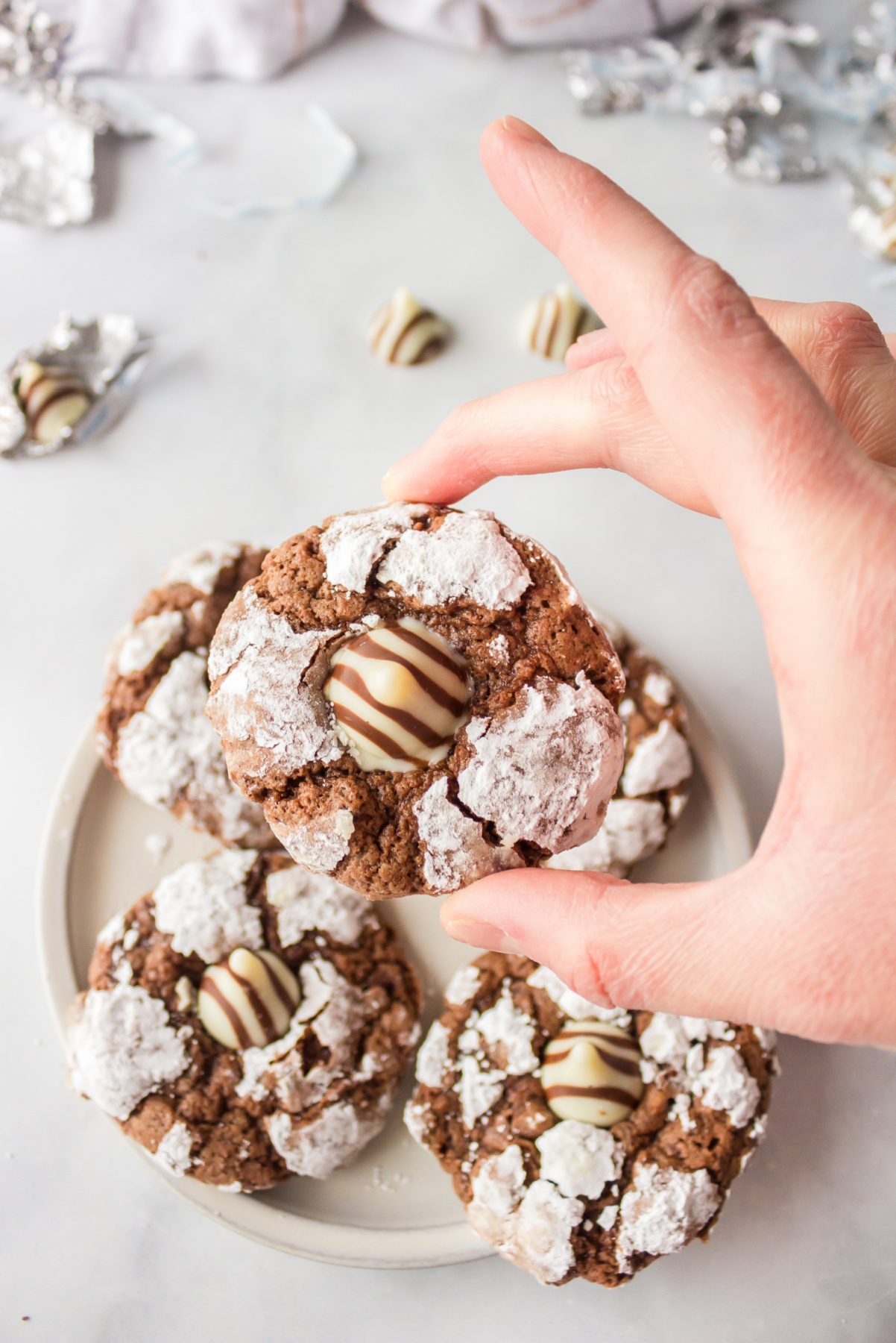 hand holding chocolate kiss crinkle cookie